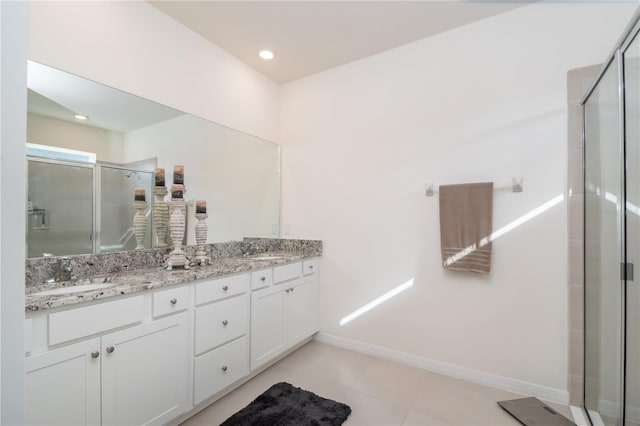 bathroom featuring tile patterned flooring, a shower with shower door, and vanity