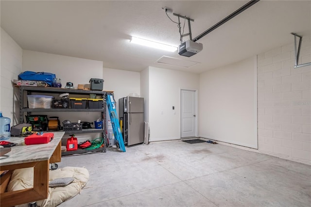 garage featuring a garage door opener and stainless steel refrigerator