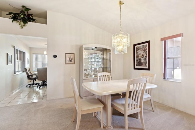 carpeted dining area featuring a chandelier