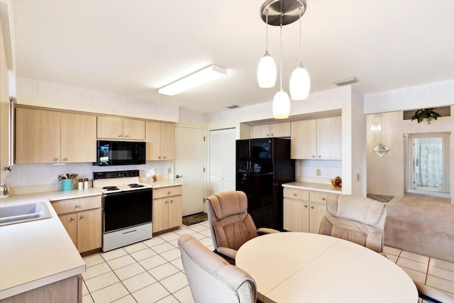 kitchen featuring hanging light fixtures, light tile patterned floors, light brown cabinetry, and black appliances