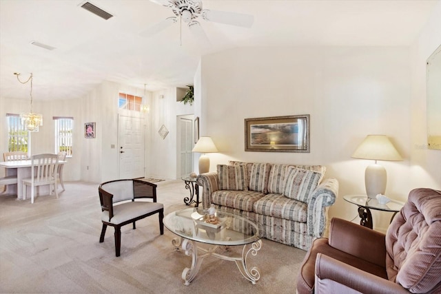 carpeted living room featuring ceiling fan with notable chandelier and vaulted ceiling