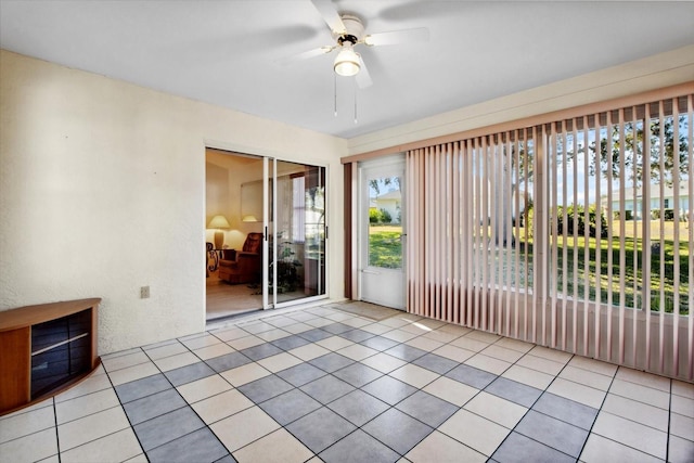 spare room featuring ceiling fan, plenty of natural light, and light tile patterned floors