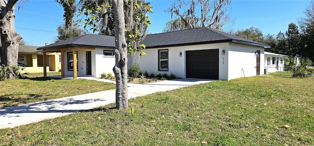 single story home featuring a front yard, driveway, an attached garage, and stucco siding