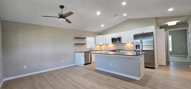 kitchen featuring open shelves, stainless steel appliances, tasteful backsplash, a kitchen island, and a sink