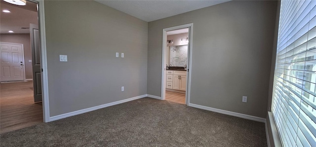 unfurnished bedroom with recessed lighting, baseboards, connected bathroom, and light colored carpet