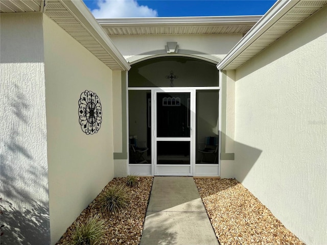 view of exterior entry featuring stucco siding