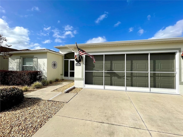 view of front facade featuring concrete driveway, an attached garage, and stucco siding