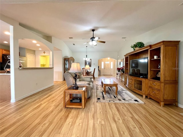 living room featuring arched walkways, light wood finished floors, lofted ceiling, and a ceiling fan