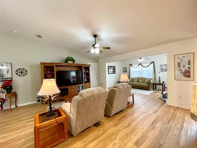 living room with ceiling fan, visible vents, baseboards, vaulted ceiling, and light wood-type flooring