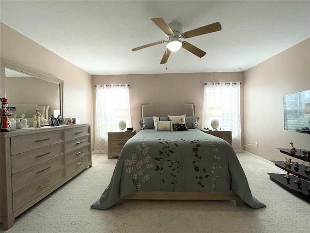 bedroom with light carpet, a textured ceiling, and a ceiling fan