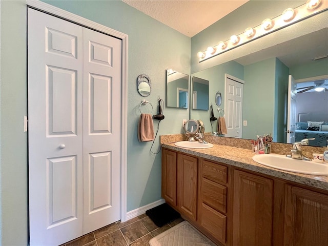 bathroom with double vanity, a closet, a sink, and tile patterned floors