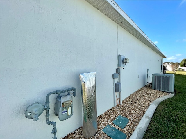 view of side of home with cooling unit and stucco siding