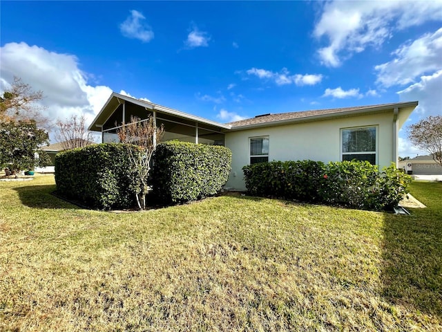 view of side of property featuring a yard and stucco siding