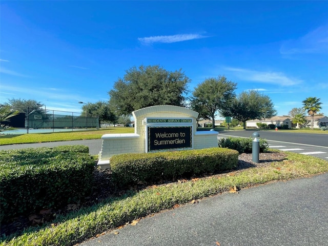 community / neighborhood sign featuring fence