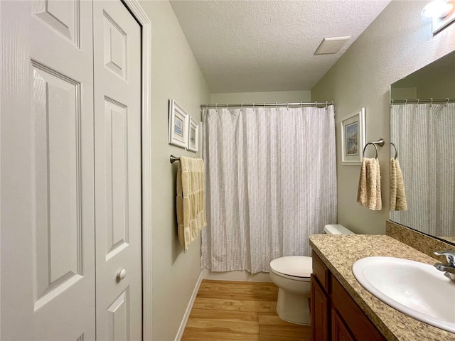 bathroom featuring a textured ceiling, toilet, wood finished floors, visible vents, and vanity