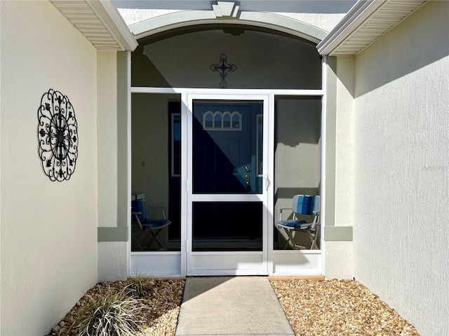 view of exterior entry featuring stucco siding