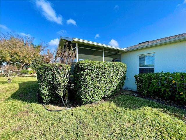 view of property exterior with a lawn and a sunroom