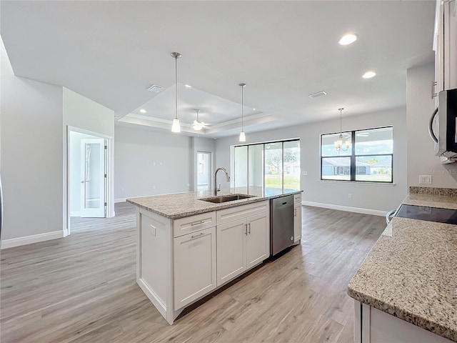 kitchen featuring white cabinets, appliances with stainless steel finishes, a kitchen island with sink, and sink