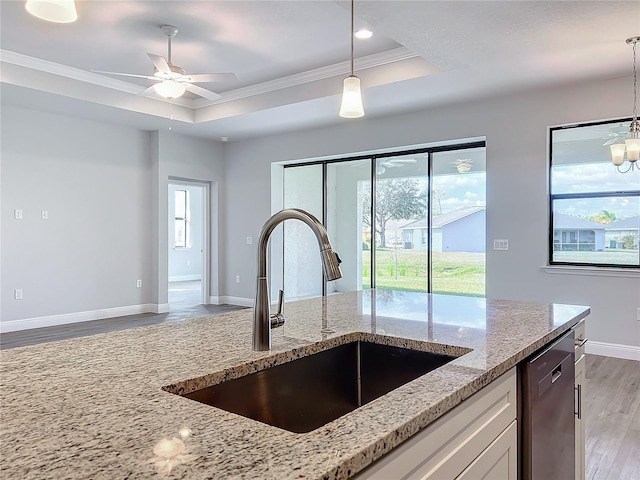 kitchen featuring dishwasher, sink, dark wood-type flooring, light stone counters, and ceiling fan with notable chandelier