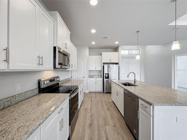 kitchen with pendant lighting, white cabinets, sink, and stainless steel appliances