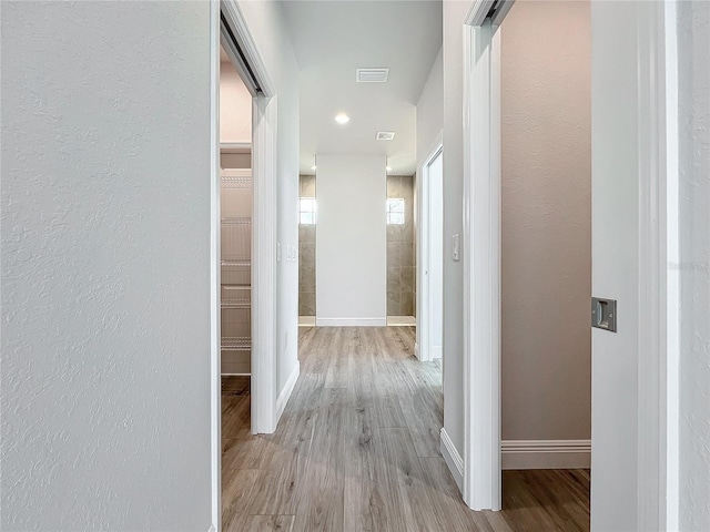 hallway with light hardwood / wood-style flooring