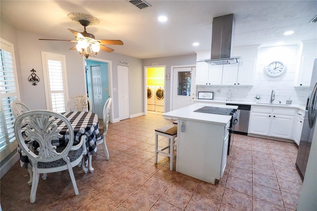 kitchen with white cabinets, a center island, independent washer and dryer, and exhaust hood