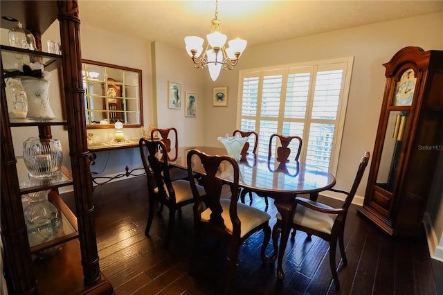 dining space with dark wood-type flooring and an inviting chandelier