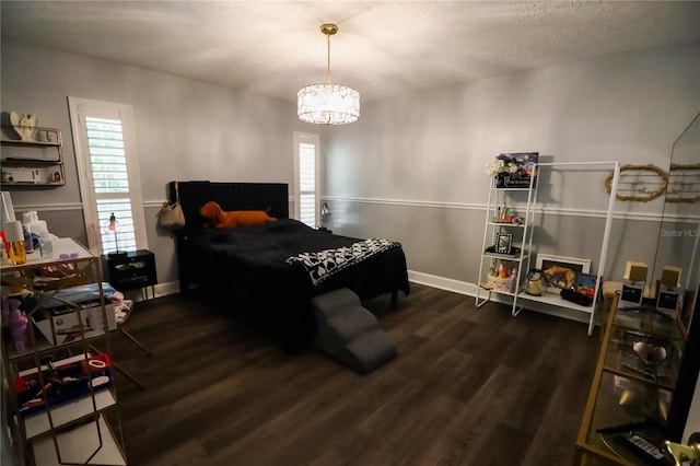 bedroom featuring a textured ceiling, dark hardwood / wood-style floors, and a notable chandelier