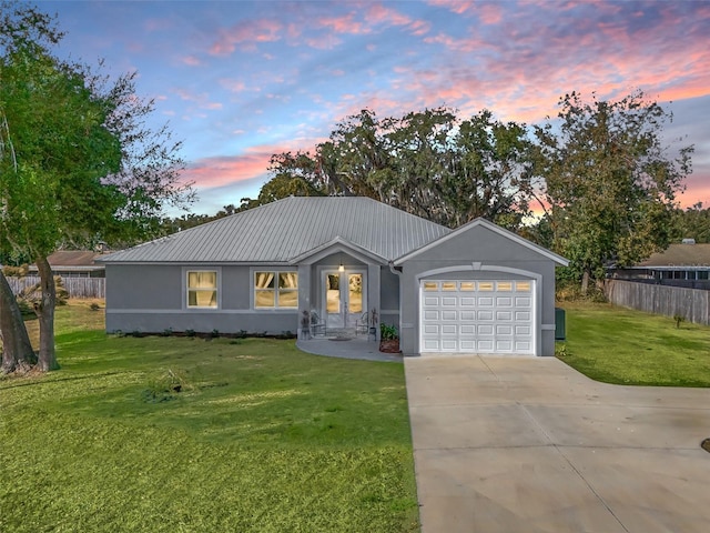 ranch-style home featuring a lawn and a garage