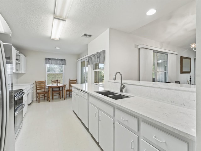 kitchen featuring white cabinetry, sink, white dishwasher, a textured ceiling, and stainless steel stove