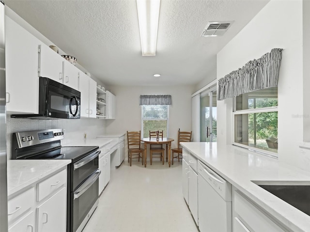 kitchen featuring electric range, white cabinets, a textured ceiling, and white dishwasher