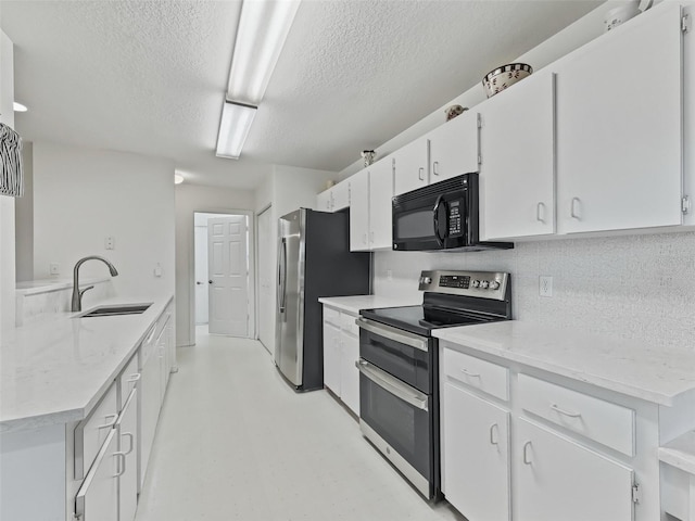 kitchen with white cabinets, a textured ceiling, stainless steel appliances, and sink