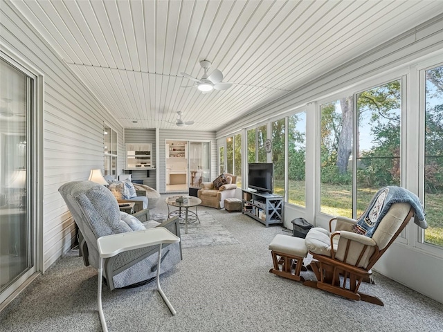 sunroom with ceiling fan and wooden ceiling