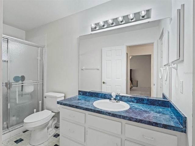 bathroom with tile patterned floors, vanity, toilet, and a shower with door