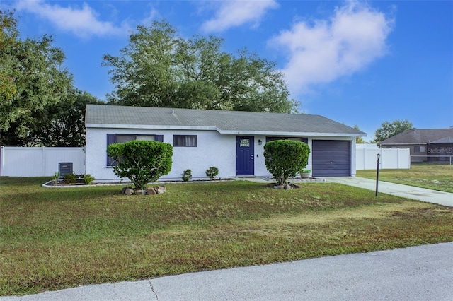 ranch-style house featuring central AC unit, a garage, and a front yard