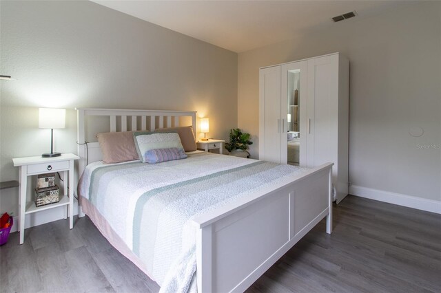 bedroom with dark hardwood / wood-style flooring