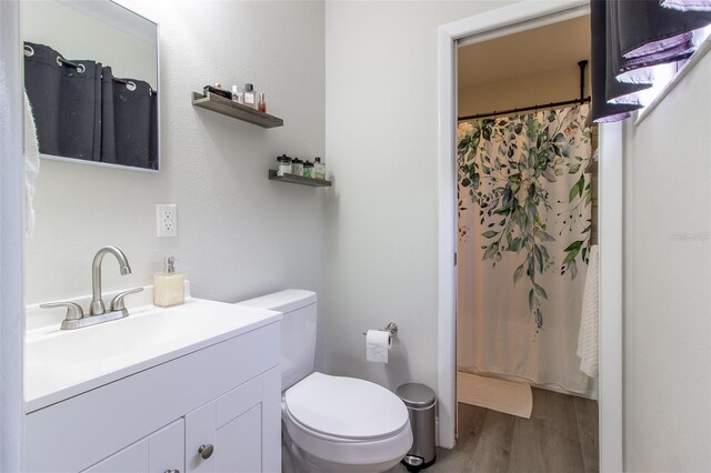 bathroom with hardwood / wood-style flooring, vanity, and toilet