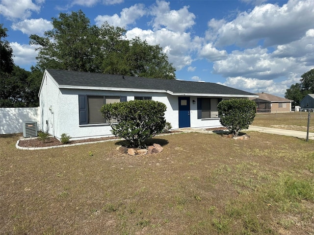 single story home featuring central AC unit, stucco siding, and a front yard