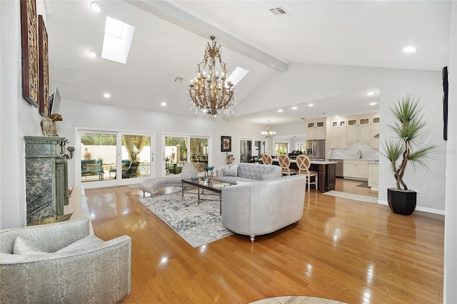 living room with beam ceiling, a skylight, a premium fireplace, light hardwood / wood-style flooring, and high vaulted ceiling