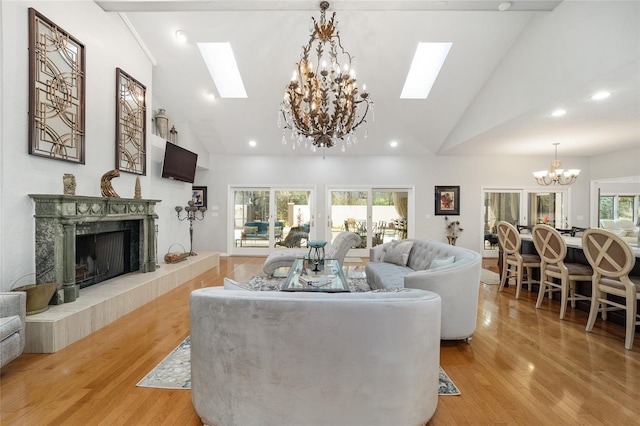 living room with light wood-type flooring, a skylight, and plenty of natural light