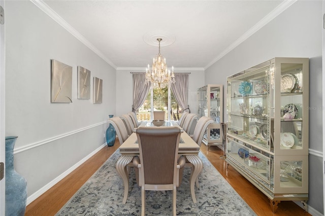 dining space featuring hardwood / wood-style floors, crown molding, and an inviting chandelier