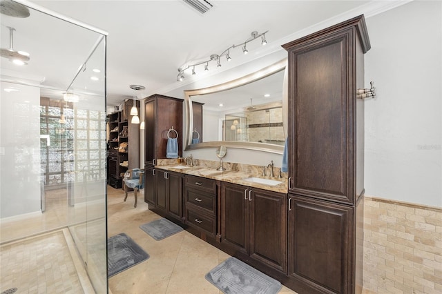 bathroom with tile patterned floors, vanity, ornamental molding, and tile walls