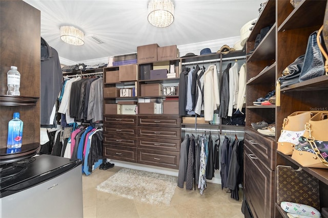 walk in closet with an inviting chandelier