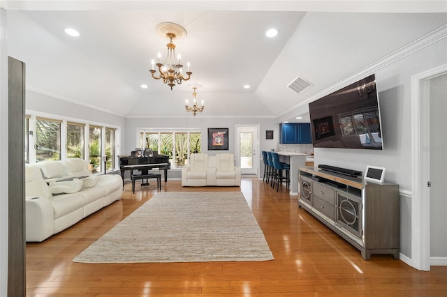 living room with a chandelier, light wood-type flooring, and lofted ceiling