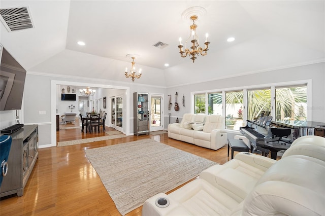 living room with ornamental molding, light hardwood / wood-style floors, vaulted ceiling, and a notable chandelier