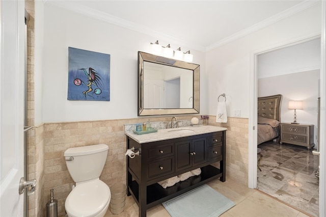 bathroom featuring vanity, toilet, tile walls, and ornamental molding