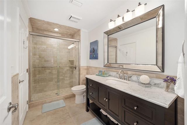 bathroom featuring tile patterned flooring, vanity, toilet, and a shower with shower door