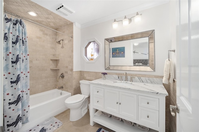 full bathroom with tile patterned floors, toilet, shower / bath combo with shower curtain, ornamental molding, and tile walls