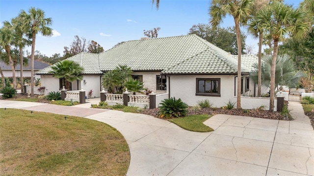 mediterranean / spanish house with a front lawn