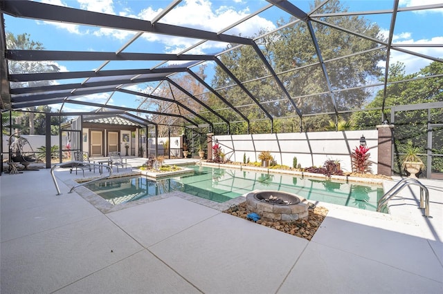 view of pool with a jacuzzi, a patio, glass enclosure, and an outdoor structure